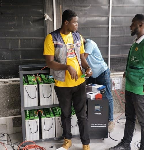 Technicians working on a battery and inverter system
